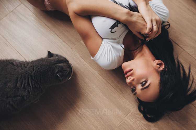 Сексуальная девушка, держащая кота на руках