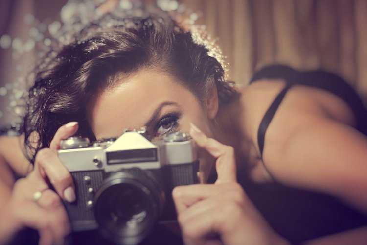 Кудрявая девушка с фотоаппаратом