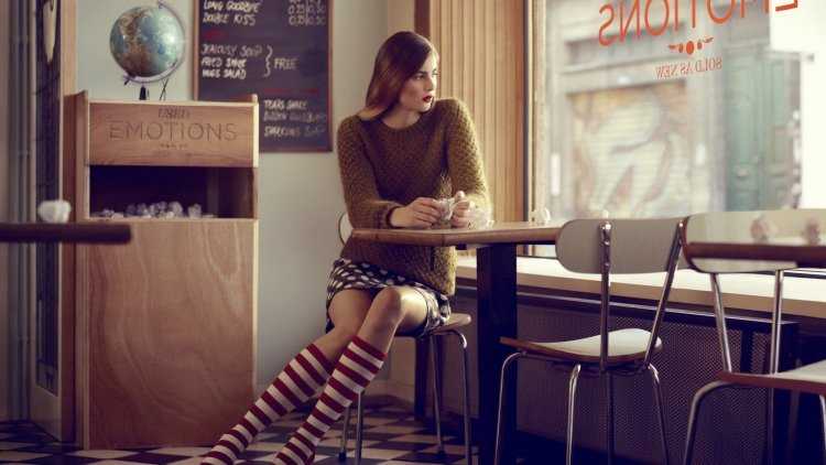 Девушка сидит за столиком в кафе