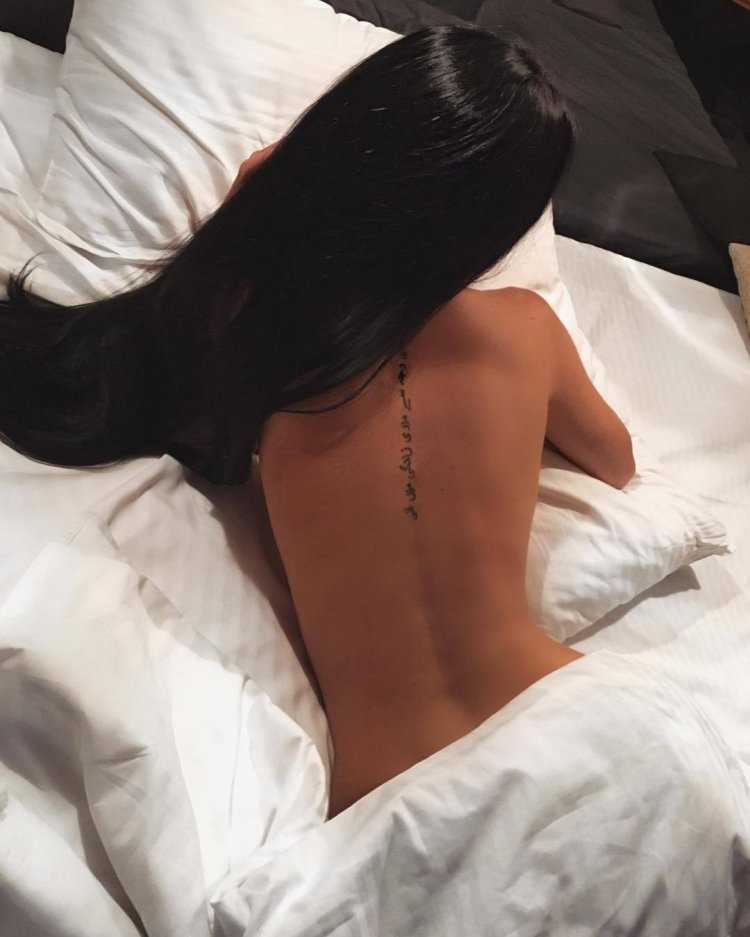 Брюнетка в постели спиной