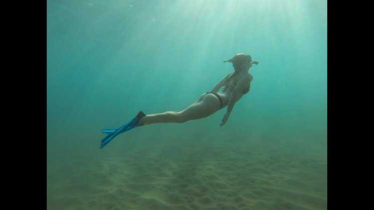 Женщина плавает под водой