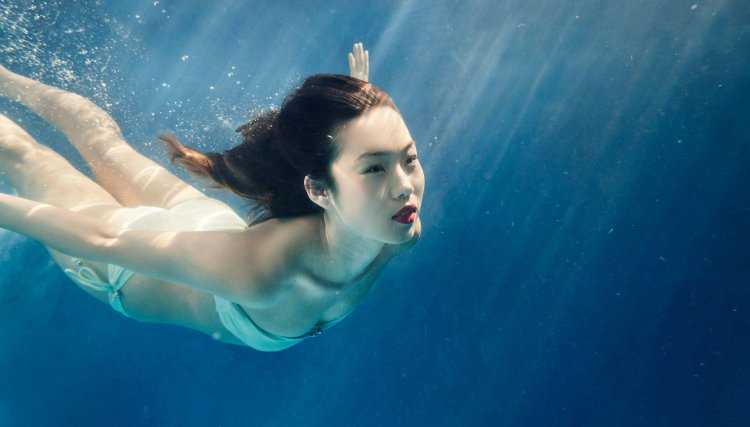 Девушка плывет под водой