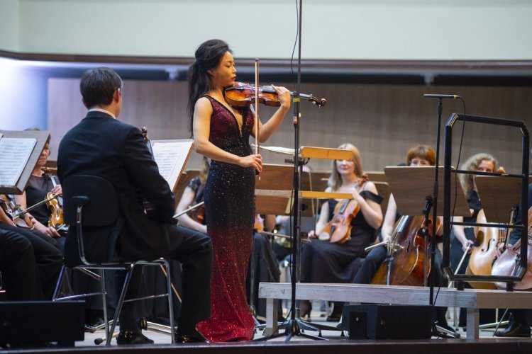 Скрипачка на сцене в платье