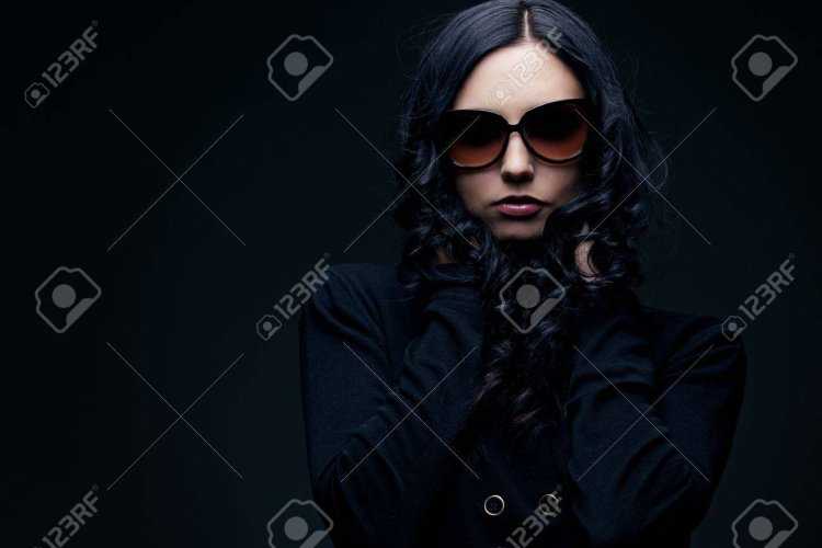 Девушка в черном костюме в очках