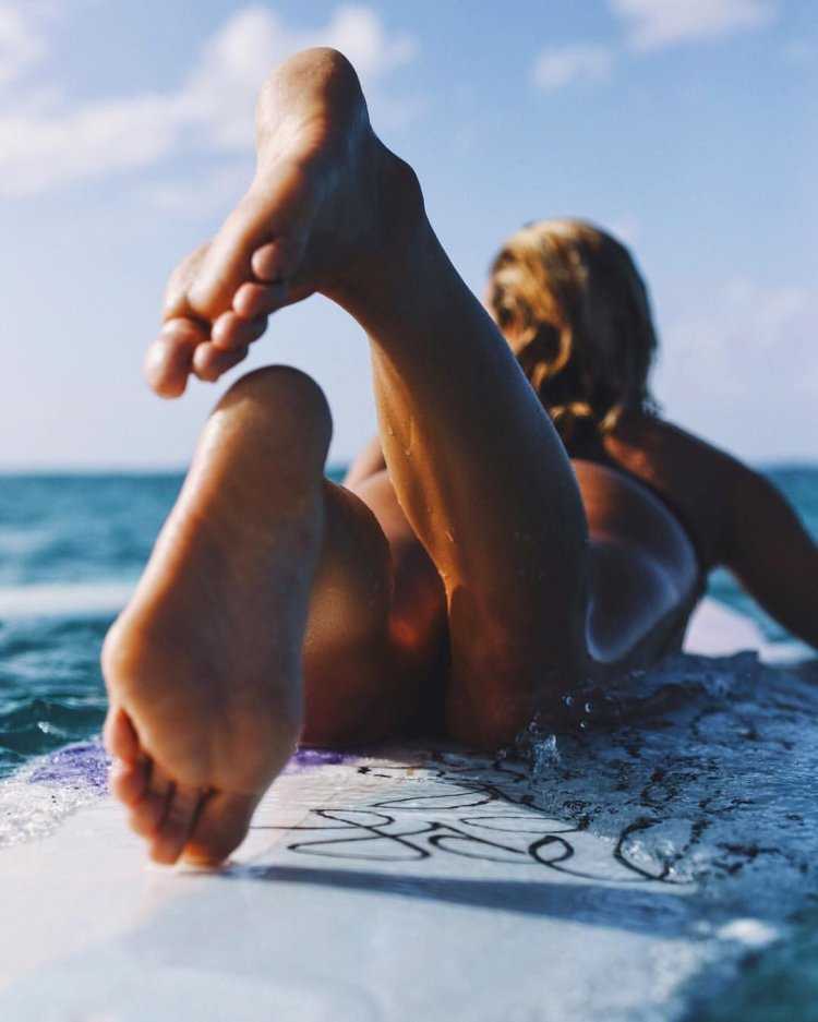 Стопы девушек на пляже