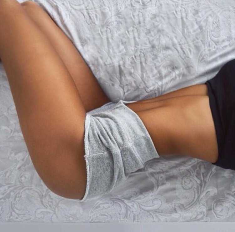 Девушка в шортах на кровати