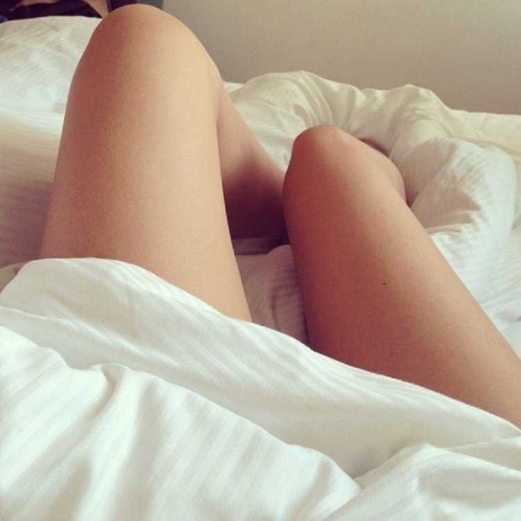 Ноги девушки в кровати