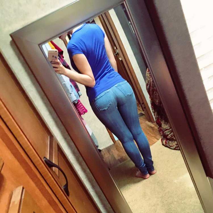 Попа девушки в джинсах селфи