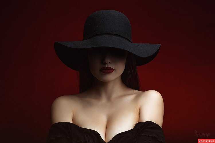 Девушка в красной шляпе на черном фоне