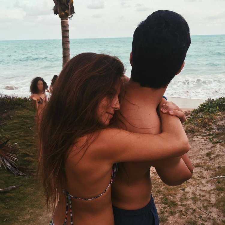 Парень обнимает девушку на море