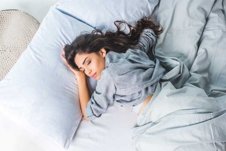 Девушка спит в кровати вид сверху