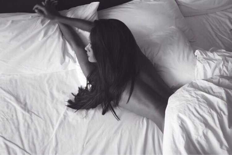 Красивая брюнетка на кровати