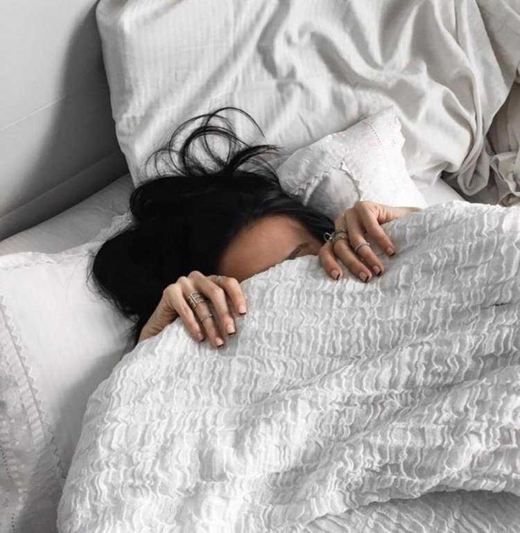 Брюнетка в постели спиной