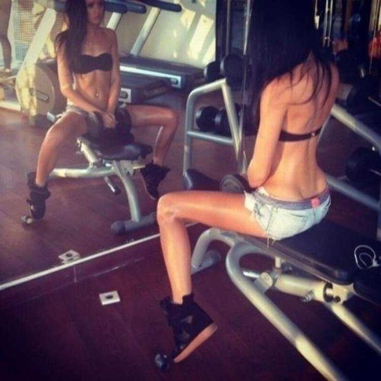 Брюнетка в спортзале без лица