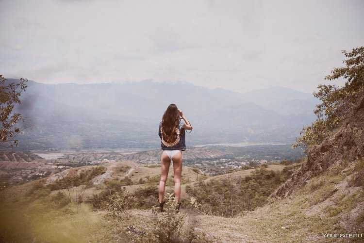 Девушка в горах со спины