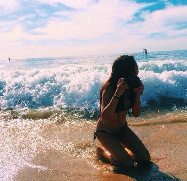 Брюнетка на море со спины