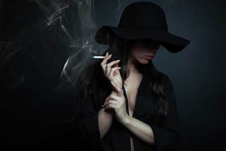 Женщина в шляпе с сигаретой