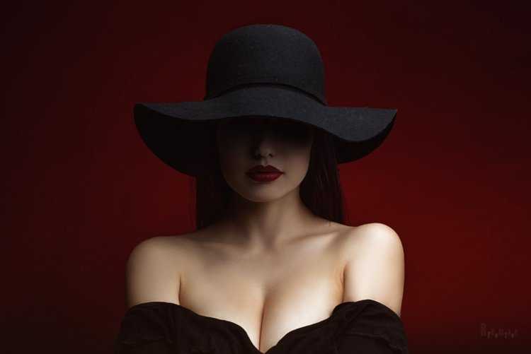 Девушка в красной шляпе на черном фоне