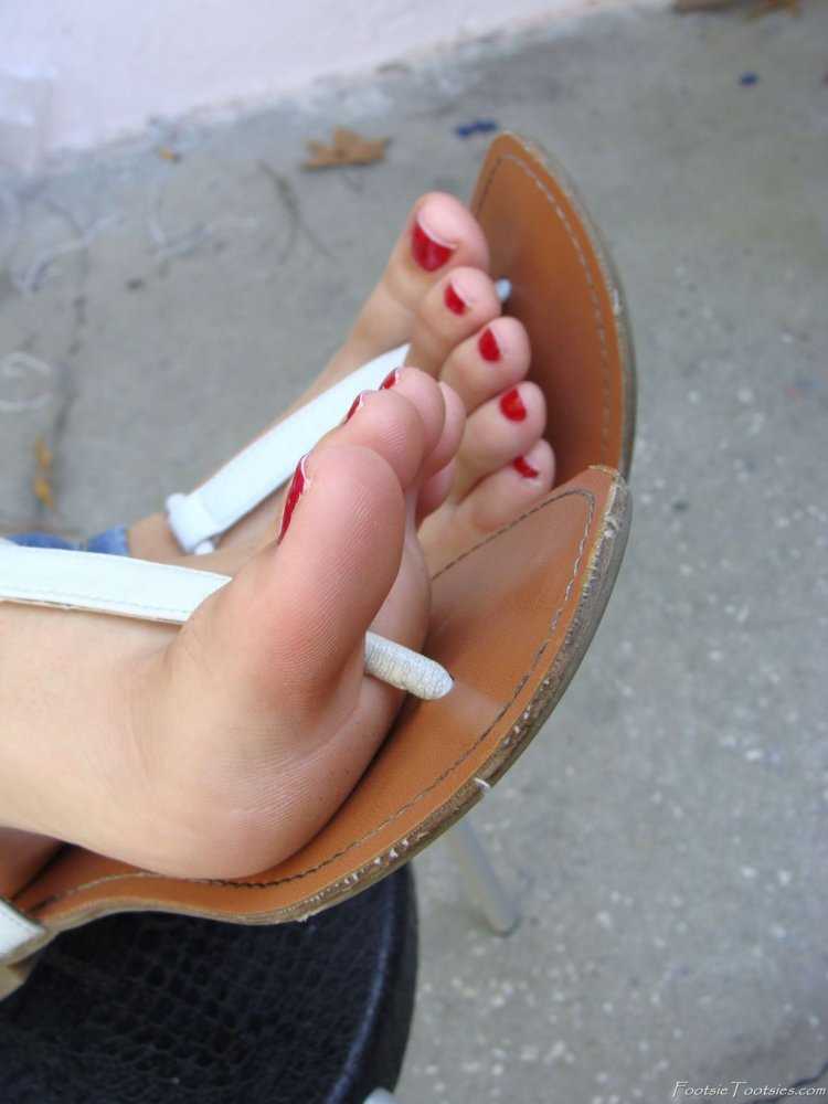 Девушка с накрашенными ногтями на ногах