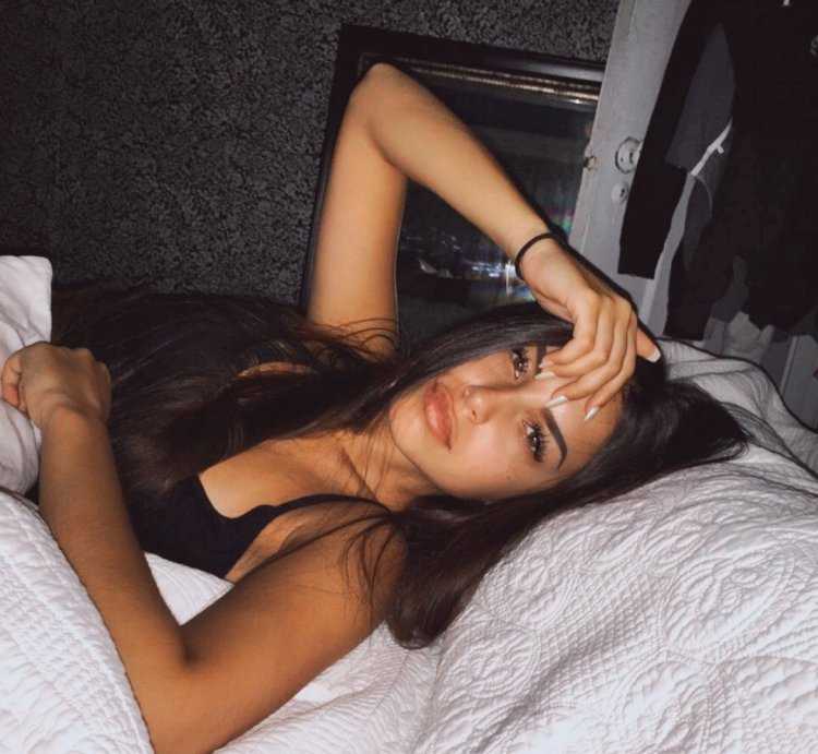 Брюнетка в постели селфи