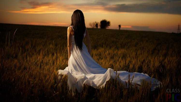 Девушка в поле со спины