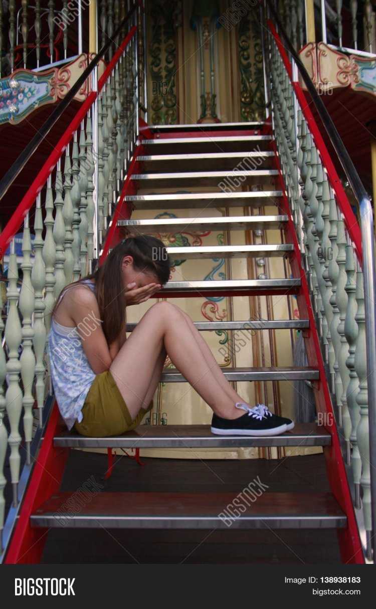 Девочка сидит на лестнице