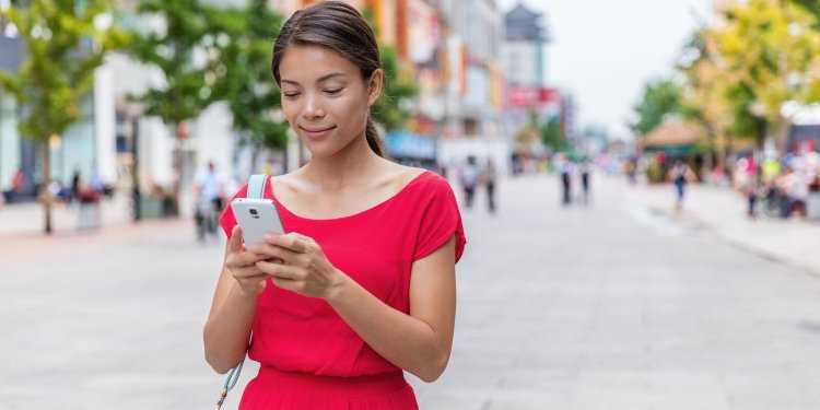 Mature woman texting on smartphone in the Street