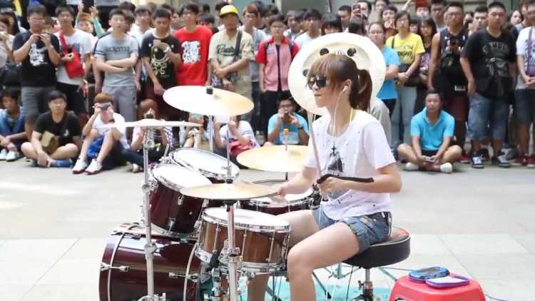 Китаянка на барабанах на улице