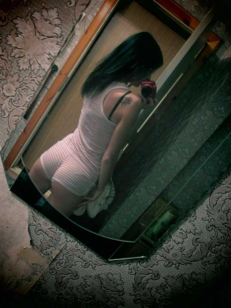 Девушка у зеркала со спины