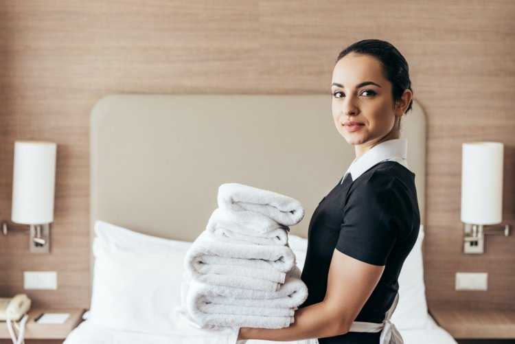 Горничная держит полотенца