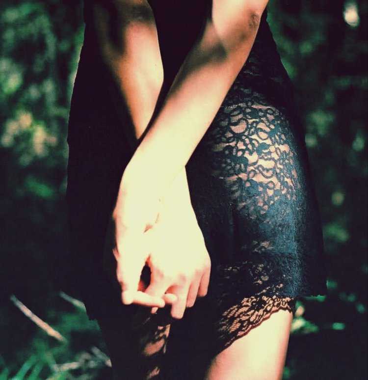 Девушка в черном платье спиной в лесу