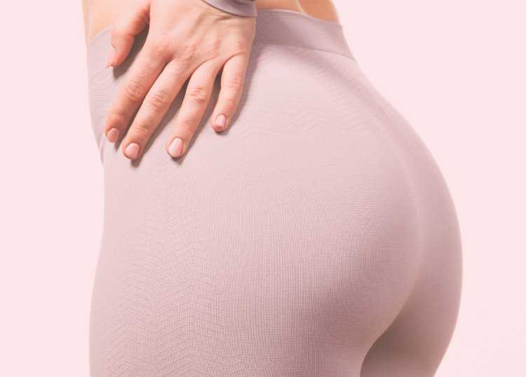 Палец на фоне попы женщины