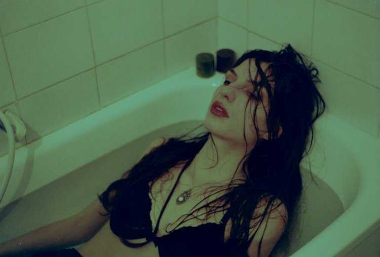 Девушка в ванне в одежде