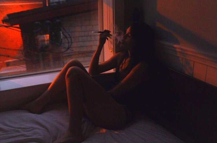 Девушка курит в темноте