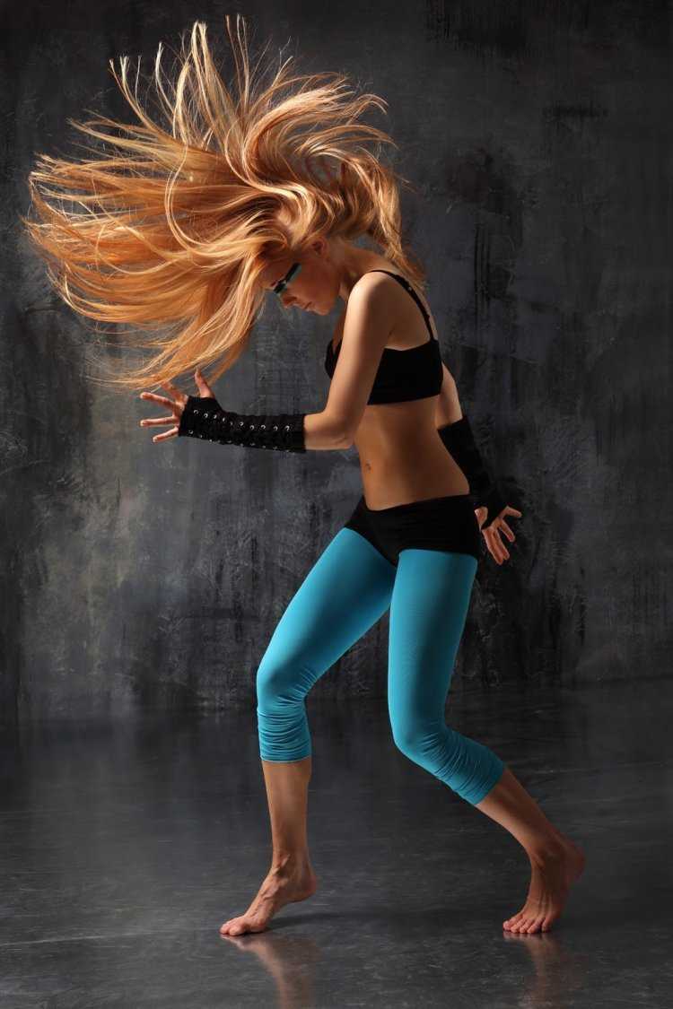 Симпатичная девушка блондинка танцует