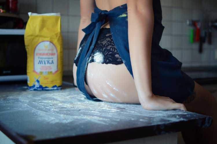 Девушка в фартуке с мукой